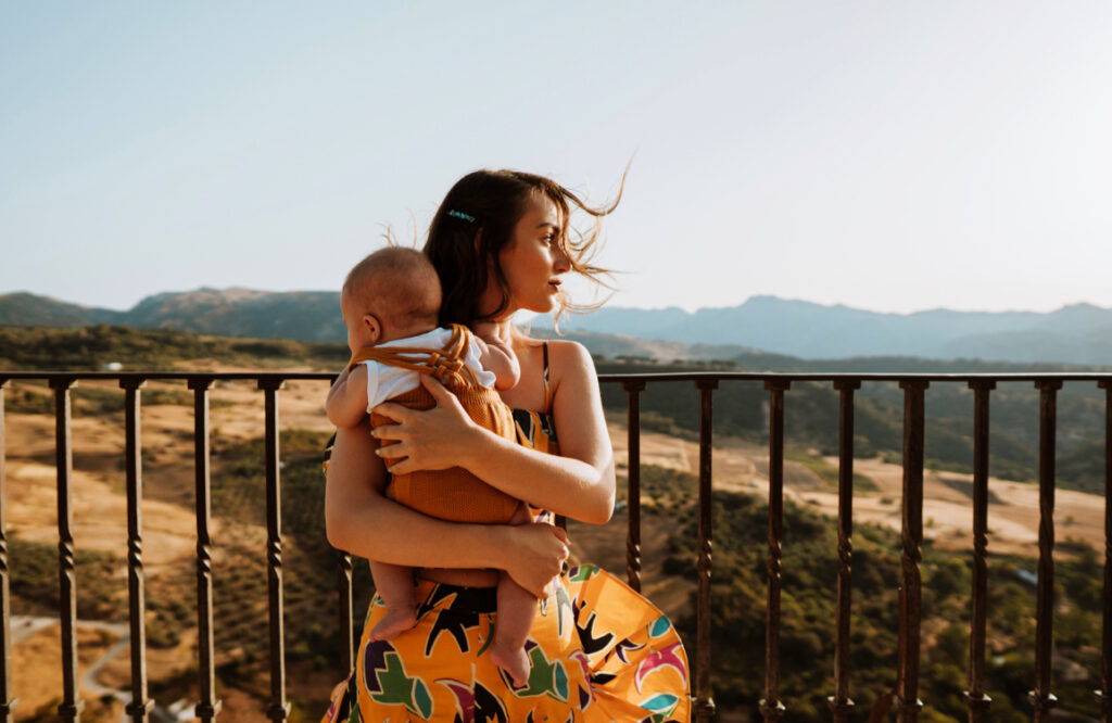 A woman wearing an orange robe  holding a baby